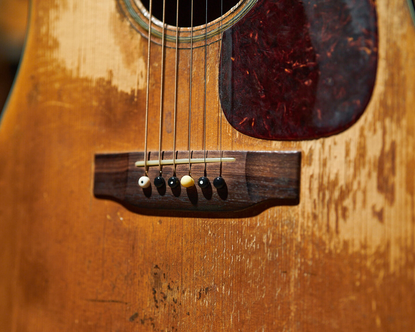 Closeup of a well-worn acoustic guitar
